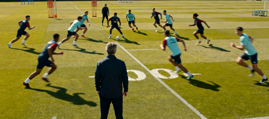 球队在训练场进行分组对抗与战术跑位演练的场景